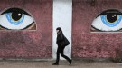 A woman walks past a building decorated with eyes in Crimean city of Sevastopol